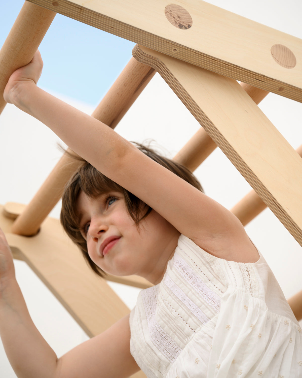 Lulu playing on the transformable pikler jungle gym