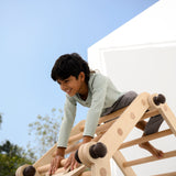 Child playing on the transformable Pikler jungle gym